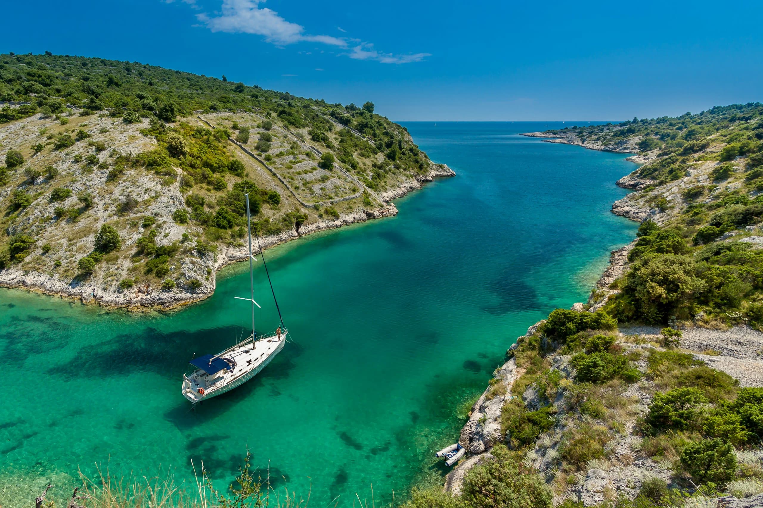 aerial-photography-of-white-boat-near-body-of-water-between-green-mountain-during-daytime-stockpack-unsplash