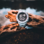 Fitness watch on a log next to the water
