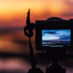 Appareil photo cadrant une scène au coucher du soleil avec des tons chauds très visibles.