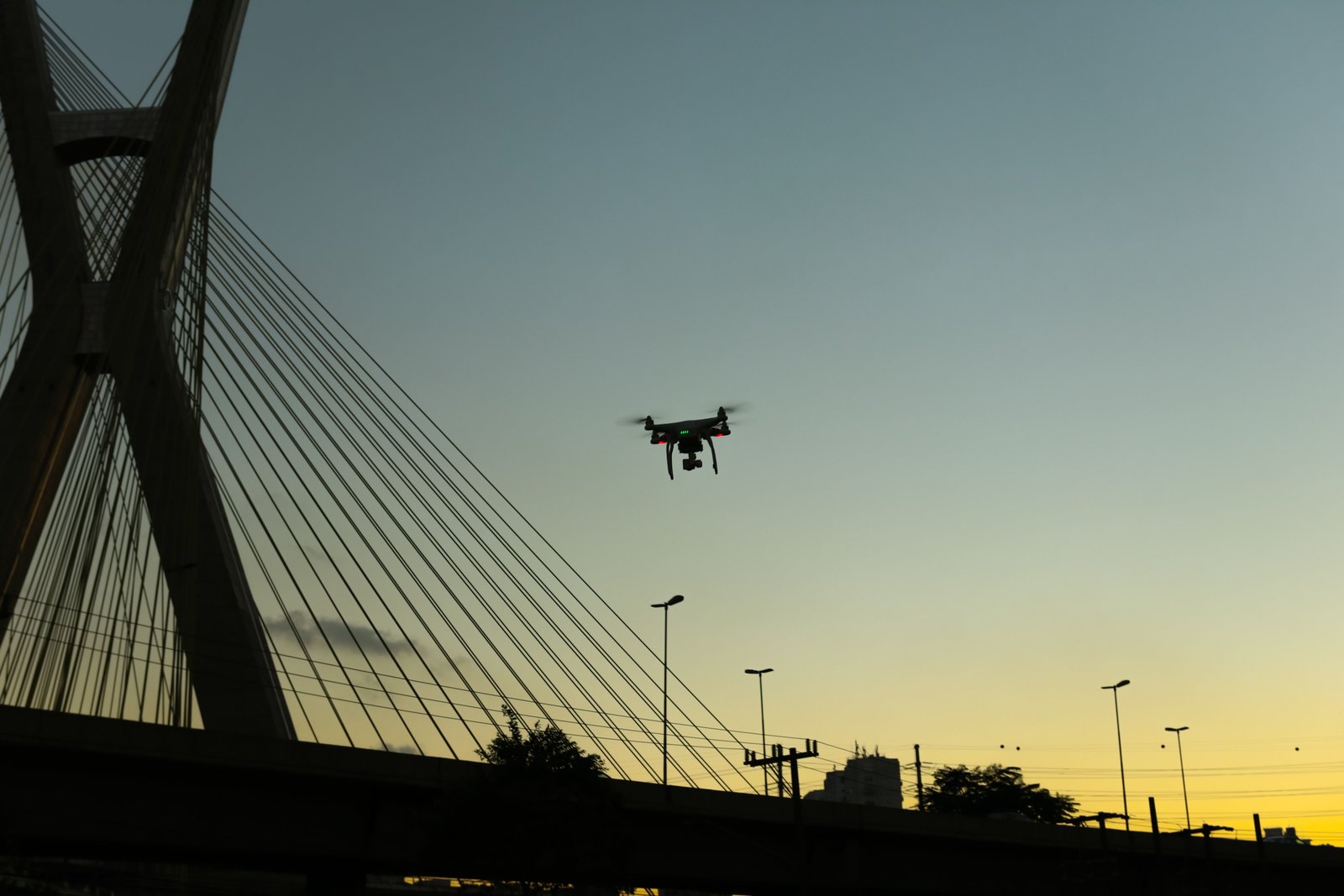 Drone en vol près d’un pont urbain, illustration des règles de vol en agglomération